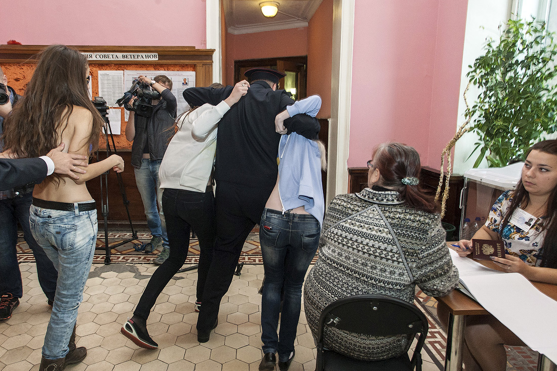 Три украинки с флагом на груди разделись на избирательном участке в Москве