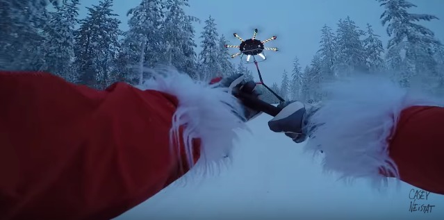 Cноубордист в костюме Санта-Клауса летает над склонами на огромном дроне