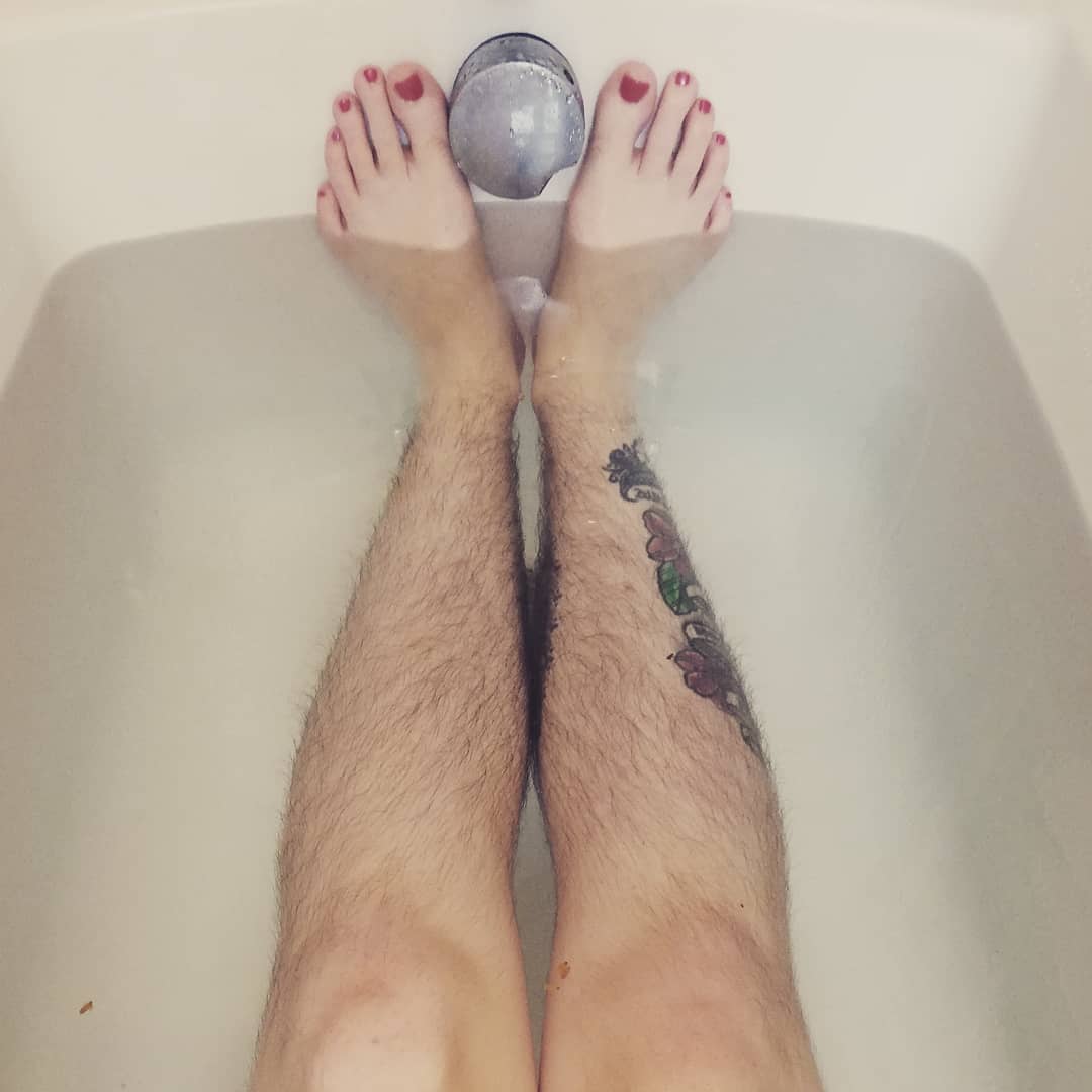 Крупным планом женщина бреет ноги после ванны