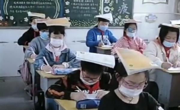 Китайским школьникам не позавидуешь. На смену странной форме пришли книги на голове, что из этого хуже