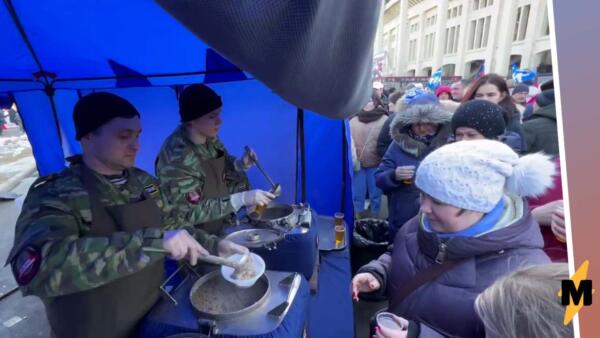 На концерте в Лужниках гости скучковались у палаток с бесплатной едой. Толпа ждёт миску гречки и чай